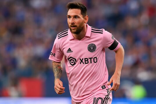 Messi Makes MLS History: Four Straight Multi-Goal Games 1 Lionel Messi wearing Inter Miami's pink jersey, running during a match.