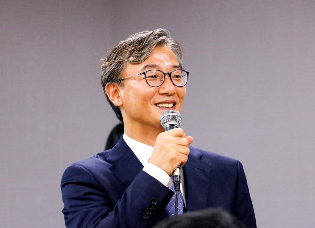 마이크를 들고 청중을 향해 웃으며 발언 중인 전재수 의원의 모습.