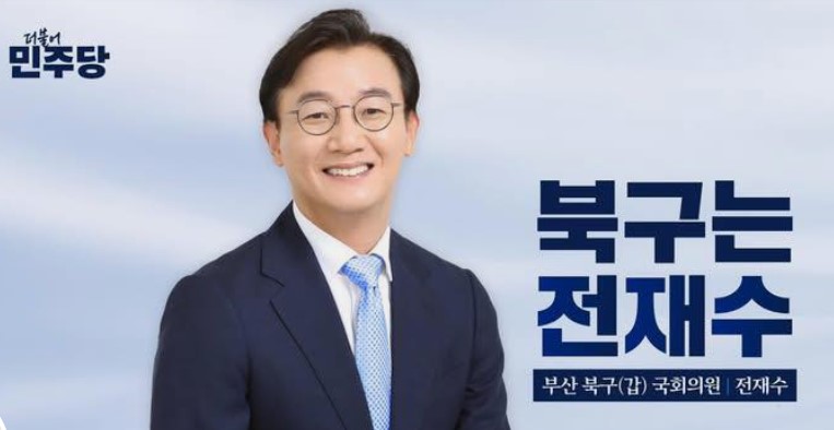 정장 차림으로 미소 짓고 있는 전재수 의원의 공식 초상 이미지, 배경에는 더불어민주당 로고와 ‘북구는 전재수’ 문구가 보임.