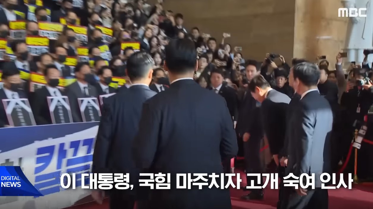 국회 건물 내에서 한 인물이 앞을 향해 고개를 숙이며 인사하는 모습